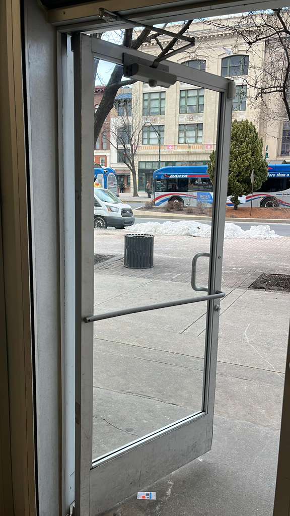 Commercial door closer repair on a storefront entry